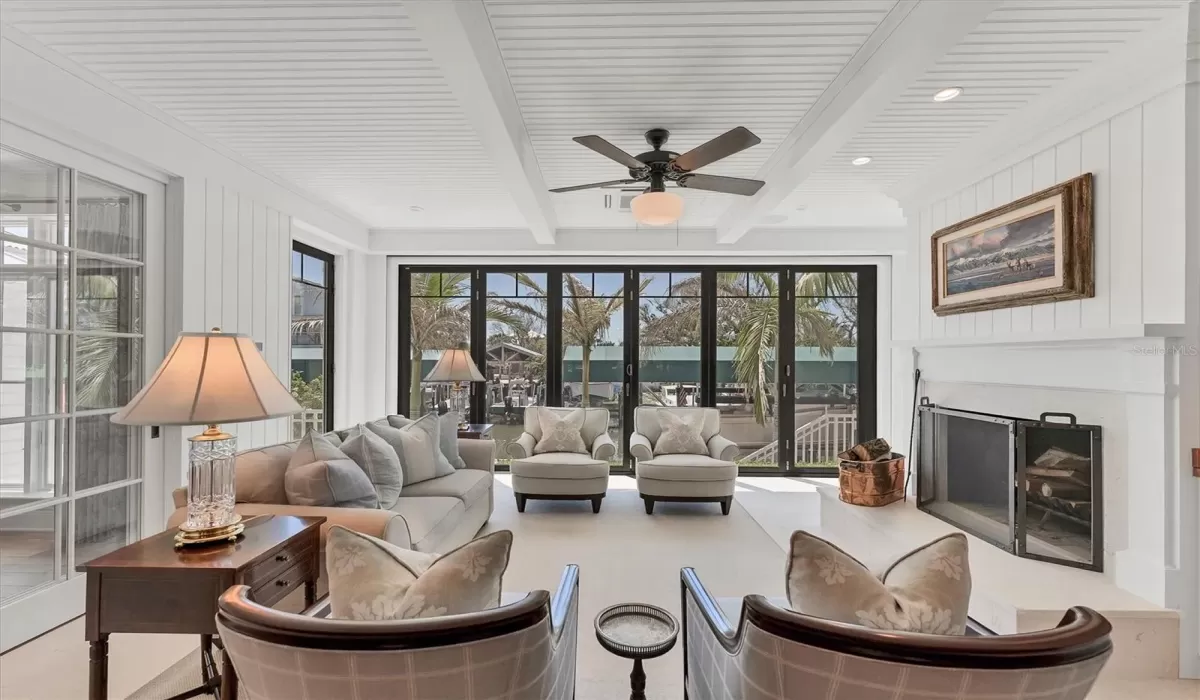 British inspired Originaluminum bi-fold patio doors (impact rated) that completely recess with an overhead motorizedretractable porch screen on-remote to create the perfect outdoor screened porch.