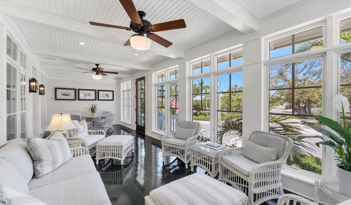 Gorgeous front sunroom with high-gloss painted green wood floors inspired by the iconic Gasparilla Inn.