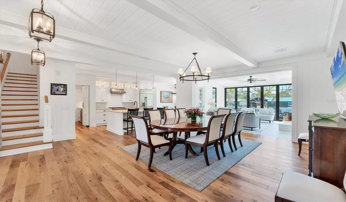 View of open-concept main living area featuring stunning antique wormy chestnut reclaimed flooring throughout the home!